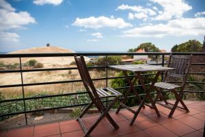 a table and chairs on a balcony with a view at Casa Da Atalaia in Caniço