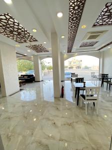 a lobby with tables and chairs in a building at Alhama Hotel Appartment in Khasab