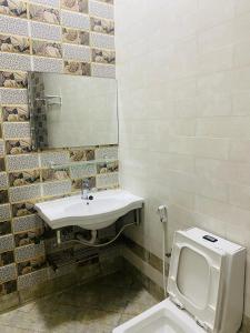 a bathroom with a sink and a toilet at Alhama Hotel Appartment in Mūkhī