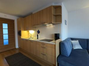 a kitchen with wooden cabinets and a blue couch at Residence Sonnberg in Perca