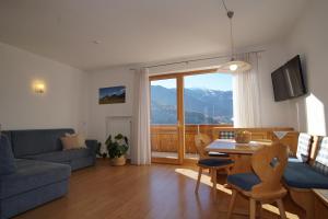 ein Wohnzimmer mit einem Sofa und einem Tisch in der Unterkunft Residence Sonnberg in Percha