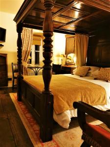 a bedroom with a large bed with a wooden canopy at The Firecat Country House Guesthouse in Mallwyd