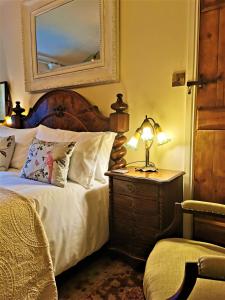 a bedroom with a bed and a table with a lamp at The Firecat Country House Guesthouse in Mallwyd