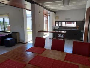 eine Küche mit einem Holztisch und roten Stühlen in der Unterkunft Casa para 4 a 6 huespedes in Mar de Ajó