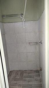 a bathroom with a shower with a tiled floor at Bloom private home in Thika