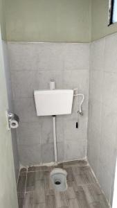ein Bad mit einem WC in einer gefliesten Wand in der Unterkunft Bloom private home in Thika
