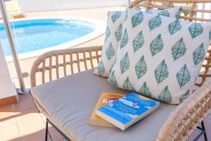 - un livre et un oreiller sur une chaise au bord de la piscine dans l'établissement Villa Abel by Algarve Vacation, à Albufeira
