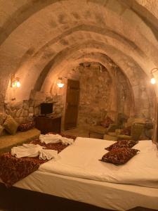 a room with a large bed in a stone room at Monte Cappa Cave House in Urgup