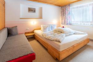 a small bedroom with a bed and a window at Haus Suban in Längenfeld
