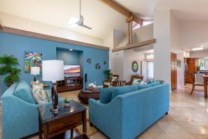 a living room with two blue couches and a tv at Lanai Villas 38 in Koloa