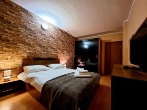 a bedroom with a large bed with a brick wall at Borovets Sequoia2 luxury Apartment in Borovets