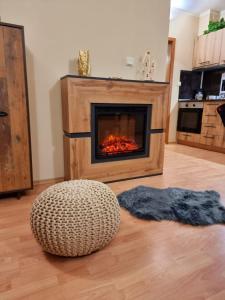 a living room with a fireplace and a ottoman at Borovets Sequoia2 luxury Apartment in Borovets