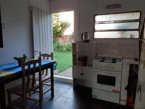 a kitchen with a stove and a table with chairs at Departamento Satí in Goya