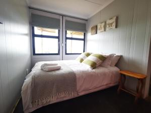 a bedroom with a bed and two windows at @Baramee in Underberg