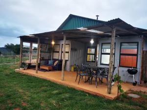 a house with a deck with a table and chairs at @Baramee in Underberg