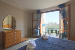a bedroom with a bed and a mirror and a table at Cosmopolitan Golf & Beach Resort in Tirrenia