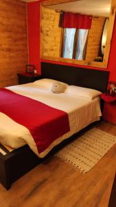 a bedroom with a large bed with a red wall at MadeBoutique Rooms in Madesimo
