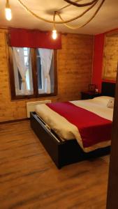 a bedroom with a large bed with a red blanket at MadeBoutique Rooms in Madesimo
