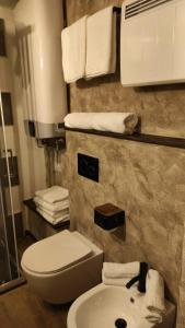 a bathroom with a toilet and a sink and towels at MadeBoutique Rooms in Madesimo