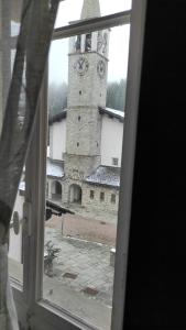 a view of a building with a clock tower from a window at MadeBoutique Rooms in Madesimo