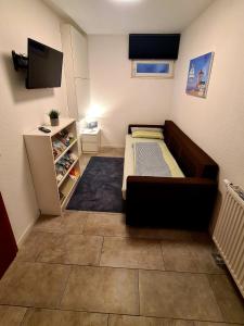 um pequeno quarto com uma cama e uma televisão em Ferienwohnung am Parkwohnstift em Bad Kissingen
