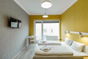 two beds in a room with yellow walls at Opera Passage Hotel & Apartments in Lviv +255 photos