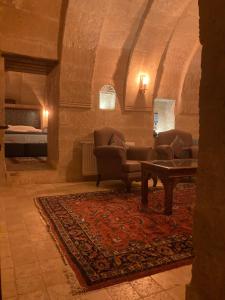 a living room with a couch and chairs and a table at Monte Cappa Cave House in Urgup