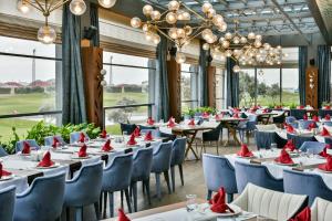Dreamland Golf Hotel Baku في باكو: غرفة طعام مع طاولات وكراسي ونوافذ