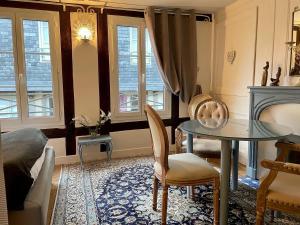 ein Wohnzimmer mit einem Tisch und Stühlen in der Unterkunft LA PARENTHÈSE DU CAPUCIN in Honfleur