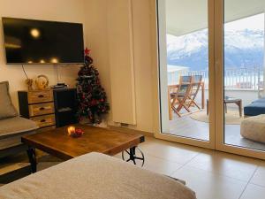 uma sala de estar com uma árvore de Natal e uma televisão em Lovely Break Annecy em Annecy