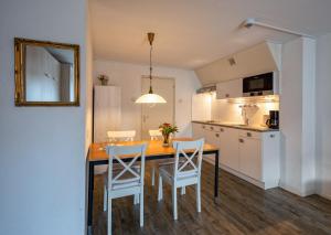 a kitchen with a table and chairs in a room at Motel Texel in De Koog