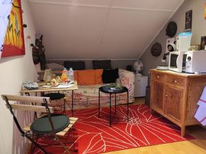 - un salon avec un canapé et un tapis rouge dans l'établissement Ô Vert'jardin, à Rochefort