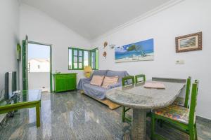 un soggiorno con tavolo e divano di El Sueño - Appartamento fronte spiaggia vista mare a Cotillo