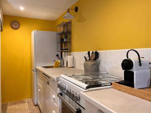 a kitchen with a stove and a white refrigerator at Maison Père in Lagarde +11 photos