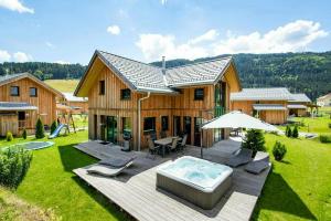 a house with a hot tub in the yard at Wellness Chalet Bell a Mur in Murau