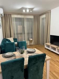 a living room with a table with chairs and a couch at Corall apartment Bar in Bar