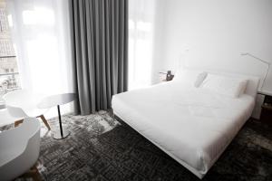 - une chambre avec un grand lit blanc et une fenêtre dans l'établissement Hotel C2, à Marseille