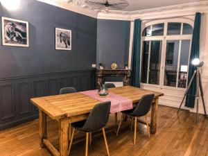 uma sala de jantar com uma mesa de madeira e cadeiras em Le Lion d'Or - Appartement d'Exception - Hyper-Centre em Arras