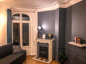uma sala de estar com um sofá e uma lareira em Le Lion d'Or - Appartement d'Exception - Hyper-Centre em Arras