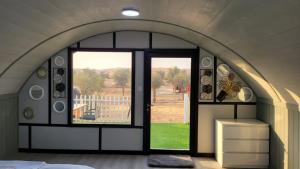 a bedroom with an arched window with a view of a yard at The Dunes Camping & Safari RAK in Ras al Khaimah