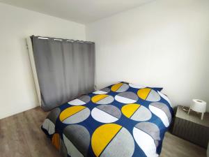 1 dormitorio con 1 cama con manta azul y amarilla en Le Babord T2 étoilé en Saint-Méloir-des-Ondes