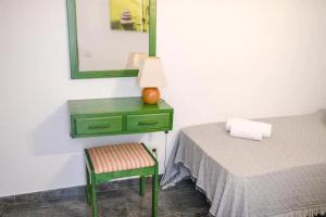 una camera da letto con cassettiera verde e sedia verde di El Sueño - Appartamento fronte spiaggia vista mare a Cotillo