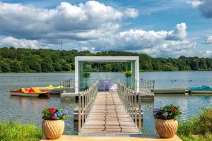 eine Anlegestelle mit einem Tisch und einem Boot auf einem See in der Unterkunft Lakeside Resort Michaela in Antrifttal
