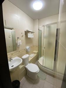 uma casa de banho com um WC, um chuveiro e um lavatório. em Deluxe SPA-Hotel em Öskemen