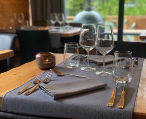 a table with forks and wine glasses on a table at Hotel L'Edelweiss in Pralognan-la-Vanoise