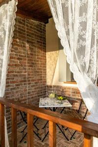 einen Balkon mit einem Tisch und einer Ziegelwand in der Unterkunft Il Mandorlo Fiorito bed and breakfast in Ogliastro Cilento