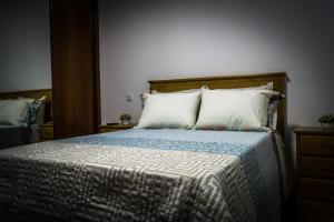 a bedroom with a bed with white pillows at Hostel Encostas Do Douro in Marco de Canaveses