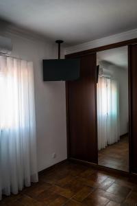 a room with a mirror and a room with curtains at Hostel Encostas Do Douro in Marco de Canaveses