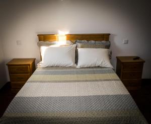 a bedroom with a large bed with two pillows at Hostel Encostas Do Douro in Marco de Canaveses +21 photos