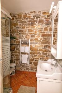 ein Badezimmer mit einem Waschbecken und einer Ziegelwand in der Unterkunft Il Mandorlo Fiorito bed and breakfast in Ogliastro Cilento